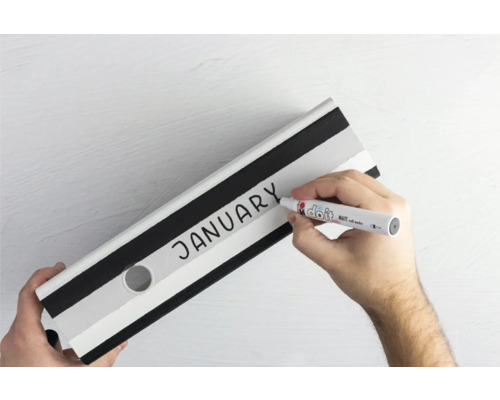 Hand beschriftet einen Ordner mit dem Wort Januar mit einem Stift