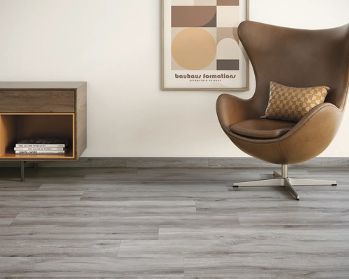 Heller Raum mit Vinylboden in Holzoptik, Sessel und Kommode