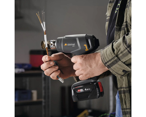 Mann verwendet ein Steinel MH 1 Akku-Heißluftgebläse zum Erhitzen von Kabeln.