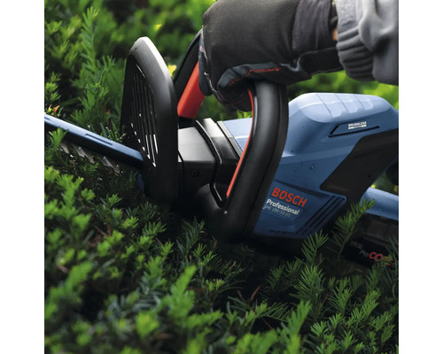 Eine Person bedient eine Heckenschere von Bosch Professional zum Schneiden einer Hecke.