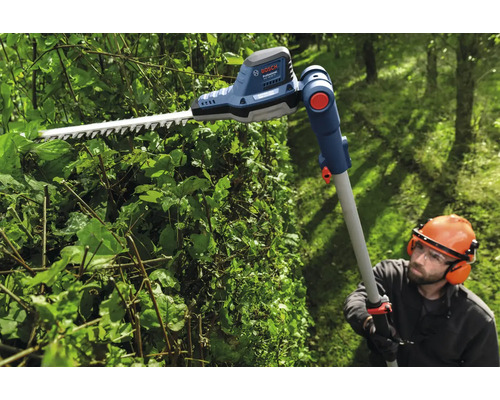 Person schneidet Hecke mit einer Akku-Teleskop-Heckenschere von Bosch