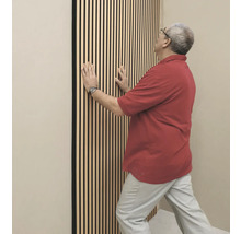 Mann befestigt Akustikpaneele an der Wand
