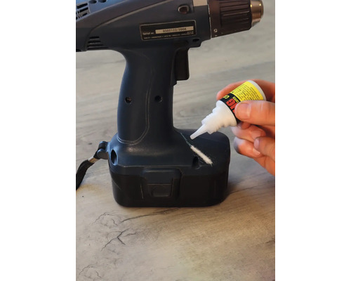 Eine beschädigte Bohrmaschine wird mit Klebstoff repariert.