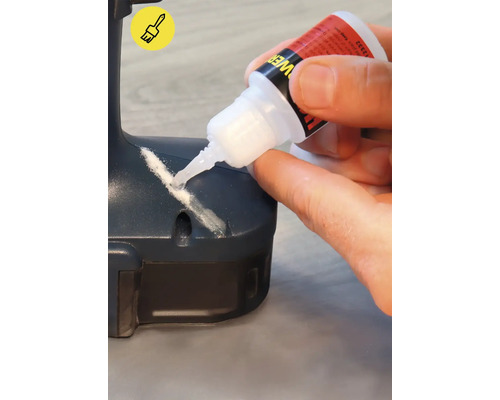 Eine Person trägt Kleber auf ein Werkstück auf.