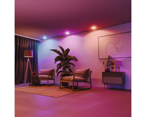 Wohnzimmer mit Zimmerpflanze, zwei Sesseln, Stehlampe, Kommode, Bild und Deckenleuchten