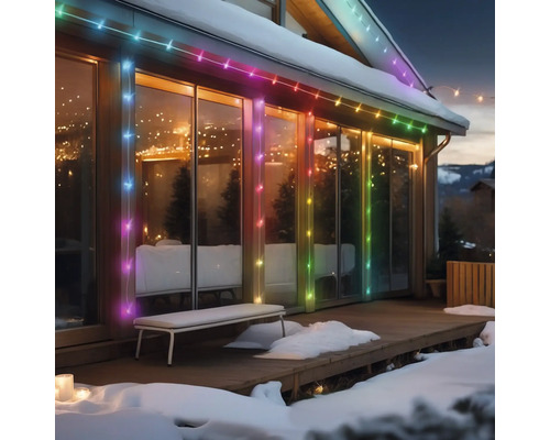 Hausfassade mit mehrfarbiger Lichterkette im Winter