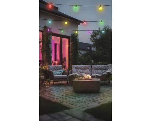 Gartenlounge mit bunten Glühbirnen an einer Lichterkette
