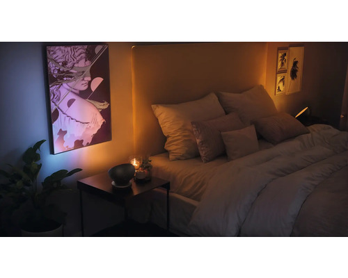 Schlafzimmer mit Bett, Nachttisch und gerahmter Kunst