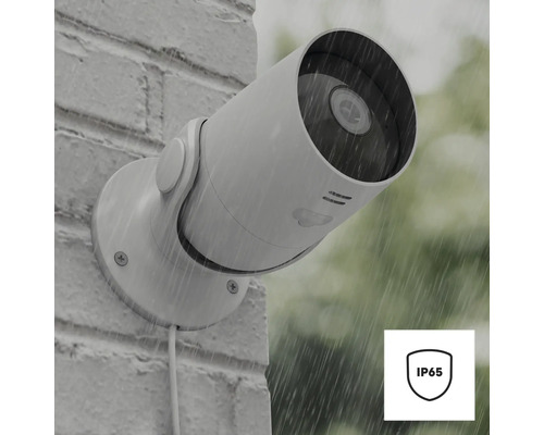 Außenkamera an einer Mauer im Regen mit IP65 Symbol für Schutz vor Strahlwasser