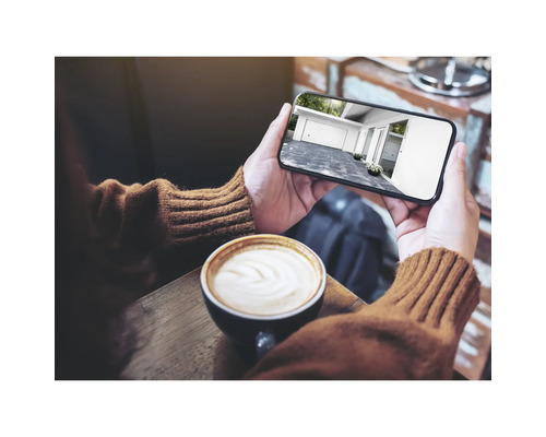 Person hält Smartphone mit Garagenansicht in den Händen