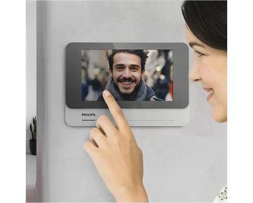 Frau nutzt Philips Türsprechanlage mit Touchscreen
