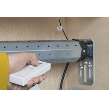 Hand mit Fernbedienung zur Steuerung eines Rollladenmotors