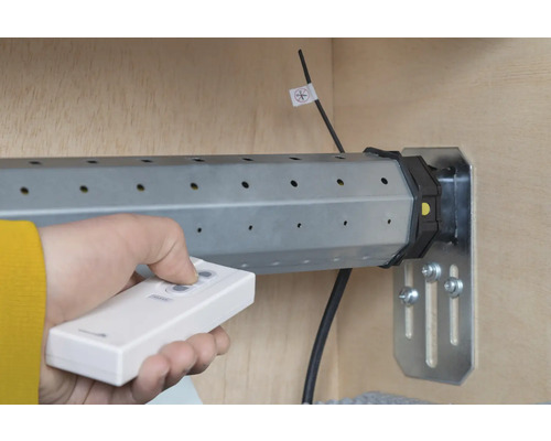 Person bedient Rollladenmotor mit Fernbedienung