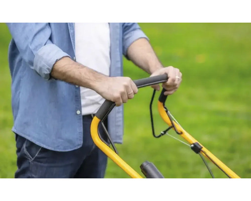 Person schiebt einen Rasenmäher