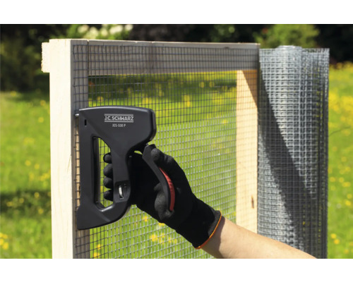 Person befestigt Drahtgeflecht mit einem J.C. Schwarz JCS-530 P Klammergerät an einem Holzrahmen