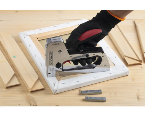 Hand mit Tacker auf Keilrahmen