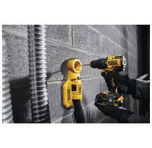 Akkubohrmaschine bohrt mit Staubabsaugung in eine Wand