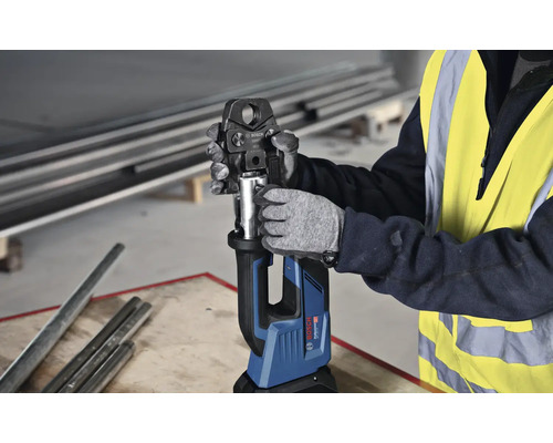 Ein Arbeiter bedient eine Bosch Akku-Presszange zum Verpressen von Rohren.