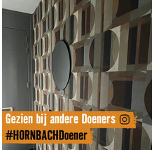Wandgestaltung mit geometrischer Tapete und rundem Spiegel