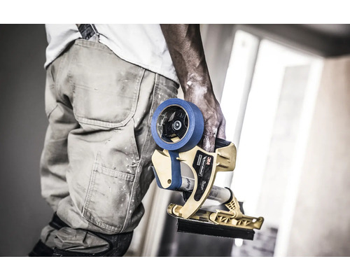 Handwerker hält Abdeckband-Applikator für Malerarbeiten