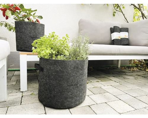 Szene mit zwei grauen Pflanzgefäßen aus Filz mit Pflanzen auf einer Terrasse