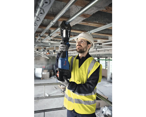 Handwerker bei der Verwendung einer Rohrzange zum Verpressen von Rohren auf einer Baustelle.