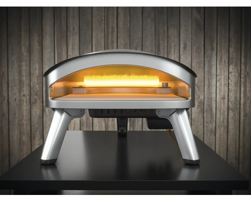 Silberner Pizzaofen auf einem Tisch mit offenem Ofenraum