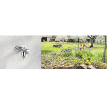 Außenwasserhahn an einer Wand mit Garten im Hintergrund