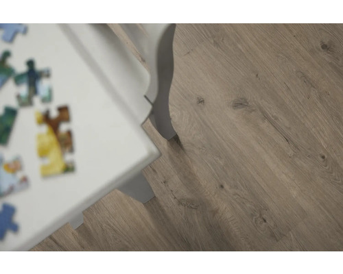 Nahaufnahme von Laminatboden mit Holzoptik und weißem Tischbein