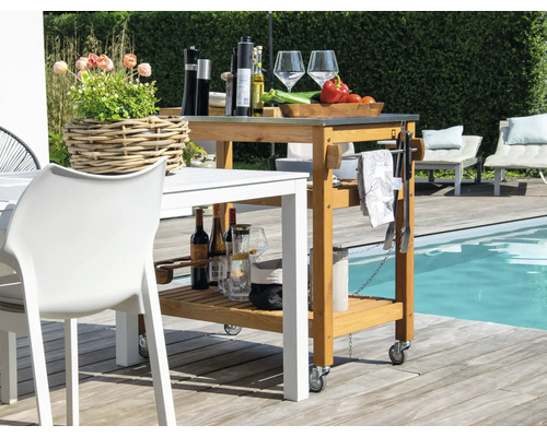 Szene mit einem Servierwagen aus Holz, der auf einer Terrasse steht.