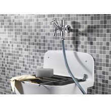 Ausgussbecken mit Armatur, Spülschwamm und Abwaschtuch vor Mosaikhintergrund