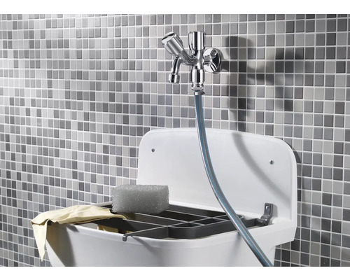 Ausgussbecken mit Armatur, Spülschwamm und Abwaschtuch vor Mosaikhintergrund