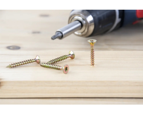 Holzschrauben und Akkuschrauber auf Holzgrund