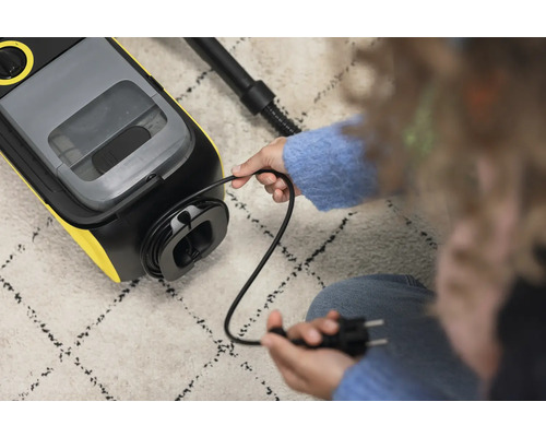 Kabelfach an einem Waschsauger mit eingestecktem Stecker