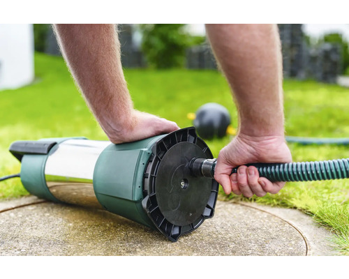 Tiefbrunnenpumpe wird an einen Wasserschlauch angeschlossen.