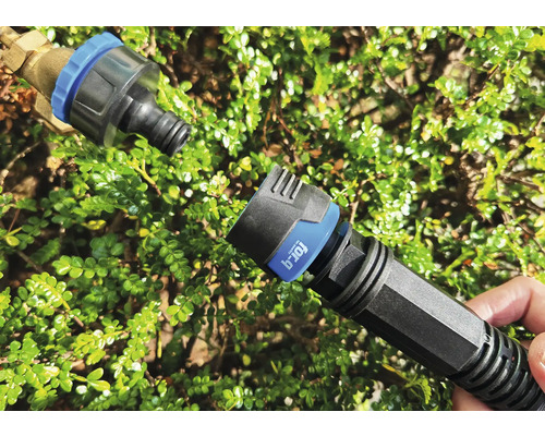 Gartenschlauch-Schnellkupplung vor grünen Blättern