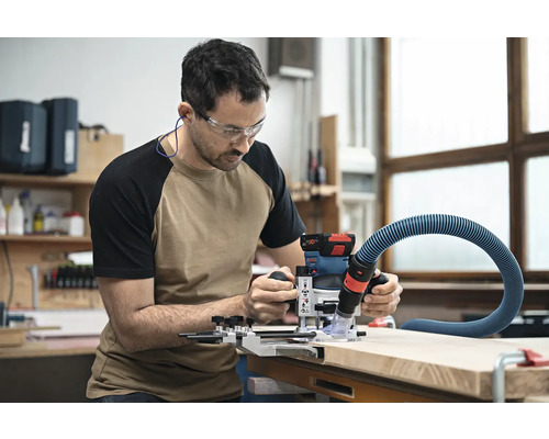 Ein Mann arbeitet mit einer Oberfräse an einem Werkstück.