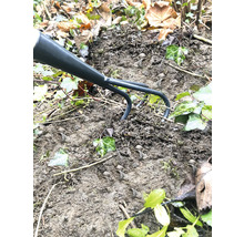 Gartenkrallengrubber im Einsatz auf einem Erdhaufen mit Efeu