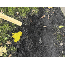 Gartenhacke mit Holzgriff im Einsatz auf dunkler Erde