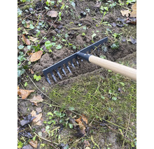 Gartenrechen mit Holzgriff beim Einebnen von Erde