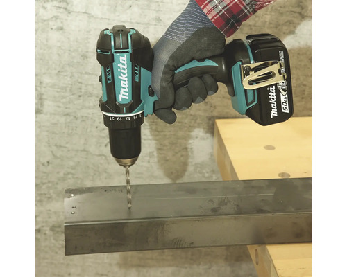 Eine Person bohrt mit einem Akku-Bohrschrauber ein Loch in ein Metallstück.