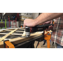 Mann schneidet Holz mit einem oszillierenden Multifunktionswerkzeug von Worx