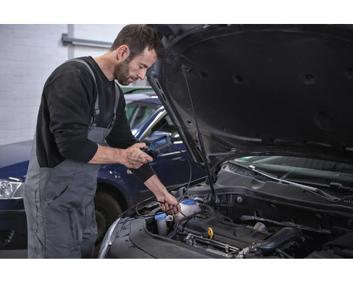 Ein Mechaniker führt eine Diagnose an einem Automotor mit einem Diagnosegerät durch.