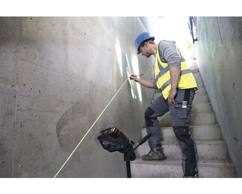 Ein Bauarbeiter verwendet einen Linienlaser zur Ausrichtung auf einer Betonwand.