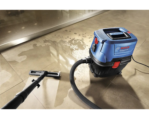 Blauer und schwarzer Nass-Trockensauger von Bosch reinigt einen gefliesten Boden