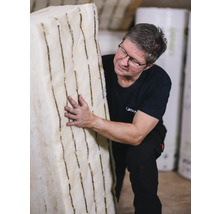 Mann hält eine Platte aus flexibler Holzfaserdämmung.