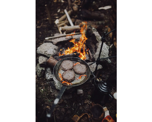 Bratpfanne mit Burgerpatties über einem Lagerfeuer