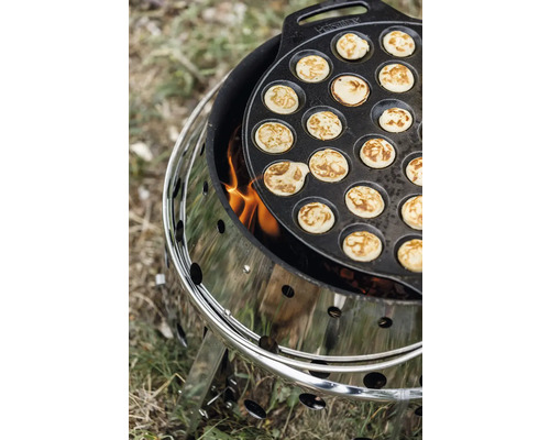 Poffertjespfanne auf einem Holzkohlegrill mit Feuer.