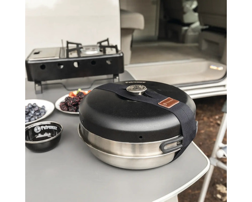 Petromax Feuertopf mit Kocher und Beeren auf einem Tisch