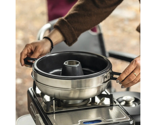 Dampfgarer auf Gaskocher mit Händen